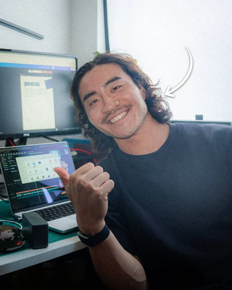Aaron Yong, founder of AY Creations, giving a thumbs up at his editing desk